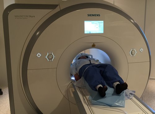 Person lying in fMRI scanner with their head first. 