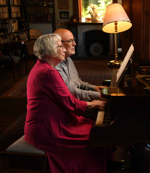 Photo of Uta Frith and Chris Frith playing piano